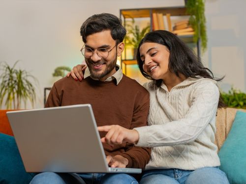 Young couple calculating a mortgage payment on their laptop.